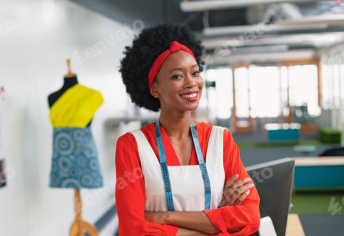 Preview: Fashion designer smiling confidently in studio with mannequin and measuring tape