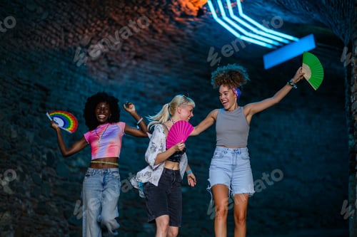 Preview: Enthusiastic friends jumping and dancing at music festival