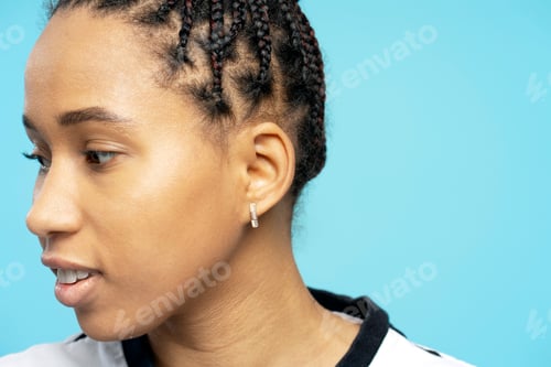 Preview: Young woman with braids looking away on blue background