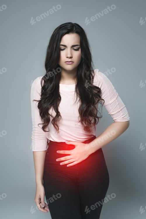 Preview: beautiful girl suffering from abdominal pain with red painful point, isolated on grey
