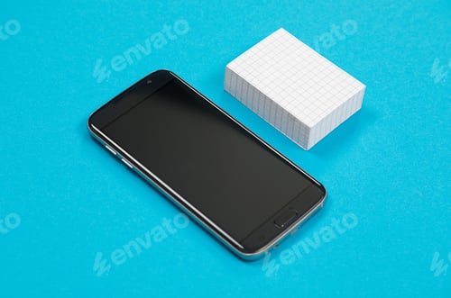 Preview: Black mobile phone and a pile of white scratch paper are lying on azure surface isolated
