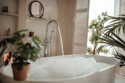 Preview: Luxury interior of big bathroom at modern african style with oval bathtub in natural lighting