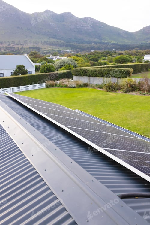 Preview: Solar panels on rooftop and scenic view of lush landscape and mountain against clear sky, copy space