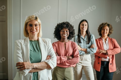 Preview: Four businesswomen standing side by side with arms crossed smiling