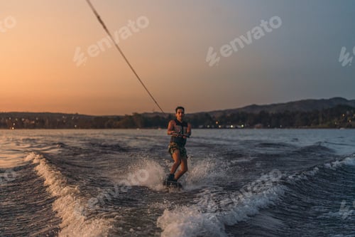 Preview: latino mas doing wakeboarding in a lake with mountains in the background