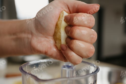 Preview: A Close Photo From The Side Of The Strong Hand Of A Woman Who Is Crushing Lemon Juice By The Hand