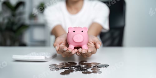 Preview: Hands Holding Pink Piggy Bank with Coins on Desk - Concept of Saving Money and Financial Planning