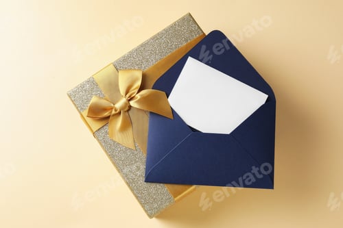 Preview: Blank card, envelope and gift box on beige background, top view
