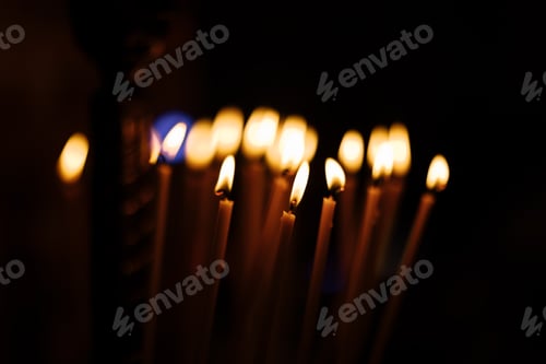 Preview: great long Candles in a church with dark background. burning candles in church on dark background.