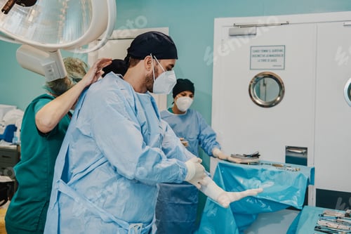 Preview: Medical doctors preparing for surgical operation inside modern hospital - Focus on male doctor face