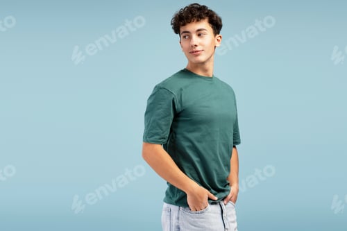 Preview: Smiling, handsome teen boy, fashion model wearing casual green t shirt, looking away on copy space