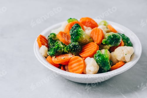 Preview: Frozen vegetables. Frozen carrots, broccoli and cauliflower in bowl on gray stone background