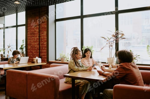 Preview: Collaborating in Cozy Modern Cafe Setting by Window