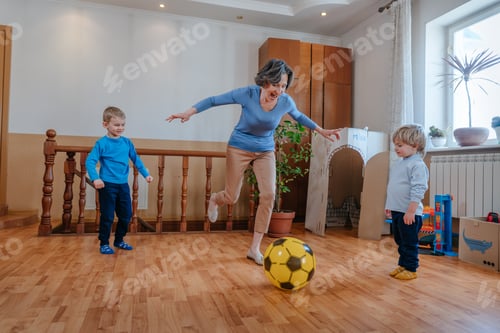 Preview: Playful Woman Kicking a Ball with Two Children