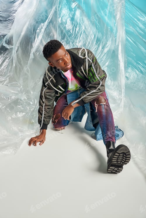 Preview: Confident african american model in outwear jacket with led stripes and ripped jeans