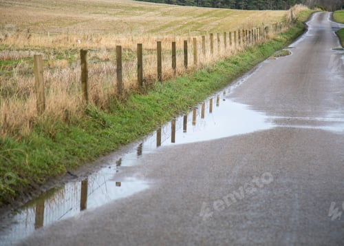 Preview: Fence posts reflecting in a puddle