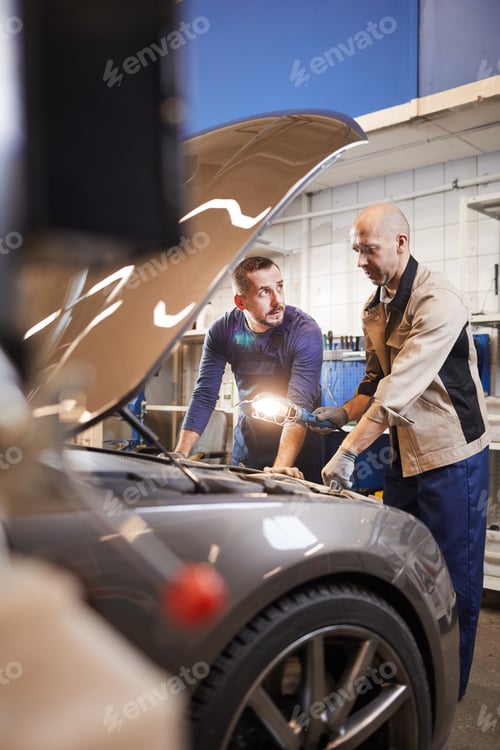 Preview: Workers Inspecting Car in Auto Shop