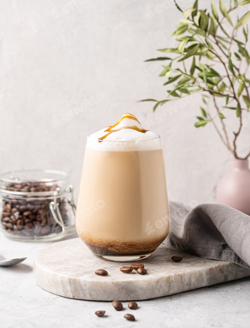 Preview: Cappuccino or latte with milk foam and caramel in a glass with coffee beans on marble background