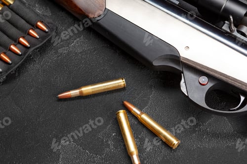 Preview: Close up of hunting shotgun and cartridges on dark grey background