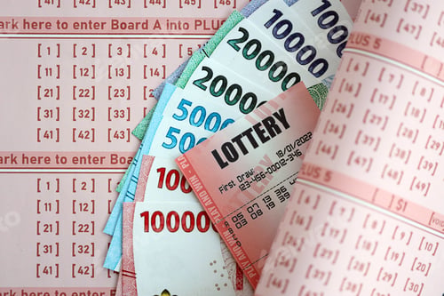 Preview: Red lottery ticket lies on pink gambling sheets with indonesian rupiah money bills