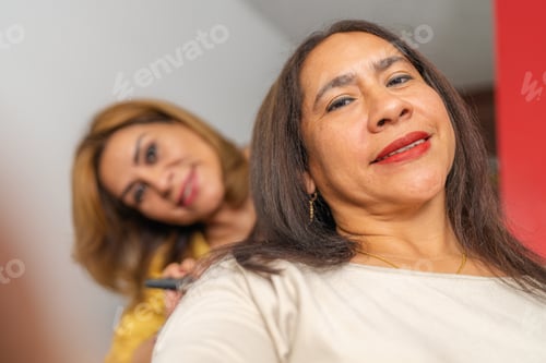 Preview: Hairdresser combing woman's hair in a beauty salon