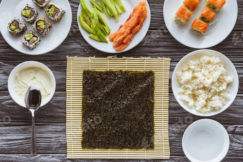 Preview: top view of nori and delicious ingredients for cooking sushi on wooden table