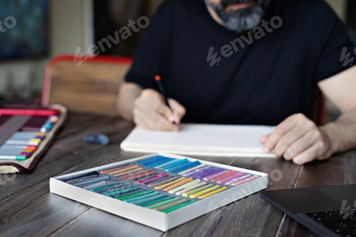 Preview: person learning online painting with pensil and pastel crayon on white sheet of paper
