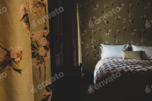 Preview: Interior view of bedroom with curtains and wallpaper with floral pattern, pale pink quilt and white