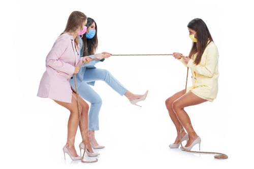Preview: Three women in pastel suits pulling rope over white background