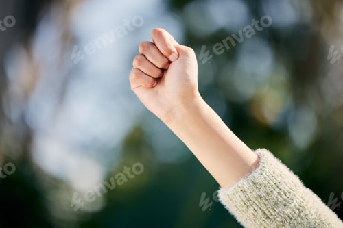 Preview: I stand for what I believe in. Cropped shot of a woman raising her fist while standing outside.