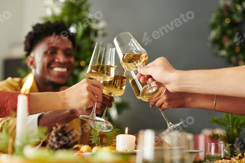 Visualização: Grupo diversificado de jovens adultos brindando taças de vinho durante a celebração do Natal