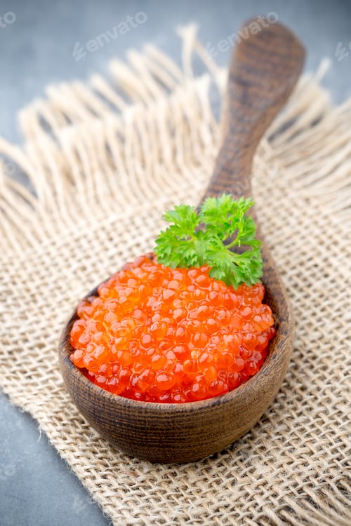 Preview: Salmon caviar with spoon on gray background.
