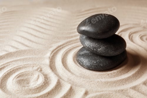 Preview: Stacked zen garden stones on sand with pattern, space for text. Meditation and harmony
