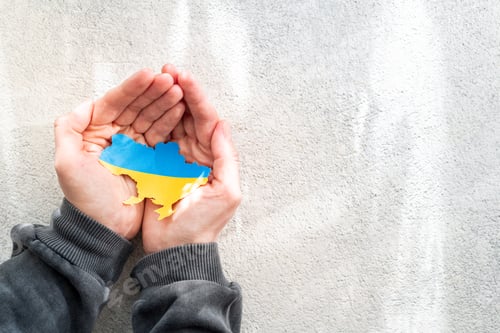 Preview: Hands holding national flag of Ukraine in the shape of the borders of Ukraine. Support for Ukraine