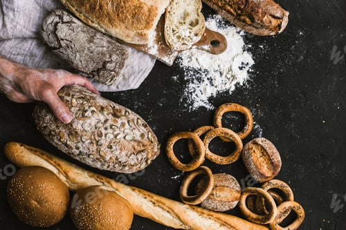 Preview: Baker man holding a rustic organic loaf of bread in his hands