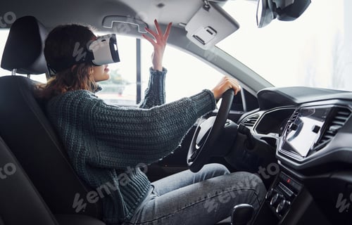 Preview: Side view of woman in virtual reality glasses that sitting inside of modern car