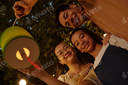 Preview: Family With Lantern Standing Outdoors