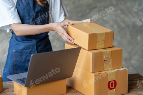 Preview: Startup happy Asian woman business owner works with a box at home, prepare parcel delivery SME suppl