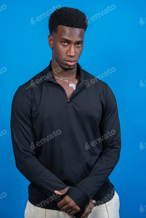 Preview: Young man wearing black shirt and africa pendant posing on blue background