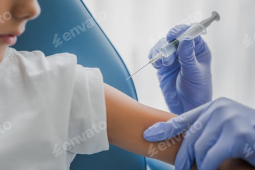 Preview: Close up of doctor injecting vaccine in boy's arm in clinic