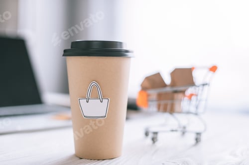 Preview: selective focus of paper cup with symbol near toy cart with boxes