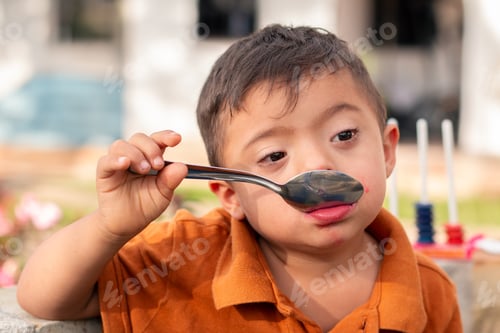 Visualização: Criança com síndrome de Down desfrutando de uma deliciosa geleia em um dia ensolarado.