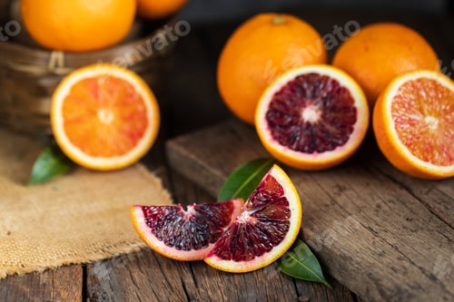 Preview: Sliced Sicilian Blood oranges fruits over old dark wooden background. Top view.