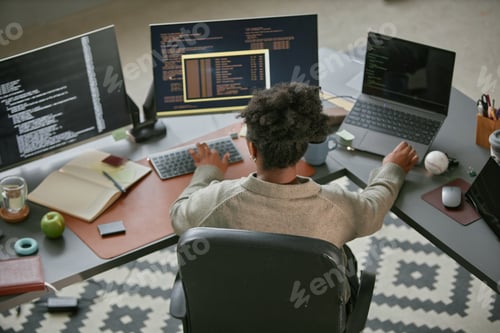 Preview: Young Adult Black Woman Working on Multiple Computers in Modern Office Setting