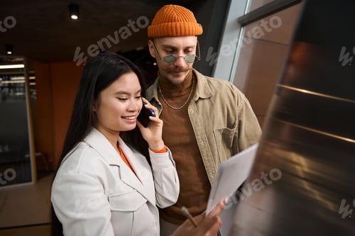 Preview: Joyous female office worker talking on smartphone