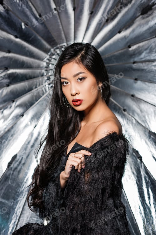 Preview: beautiful asian woman wearing ostrich feathers coat and looking at camera