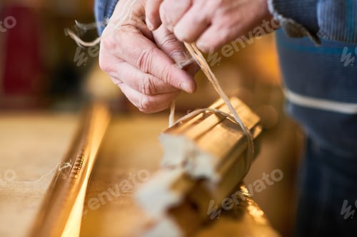 Preview: Man Wrapping Wooden Picture Frames with Twine