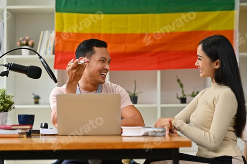 Preview: Smiling Asian male radio host and guest talking with each other recording live video podcast.