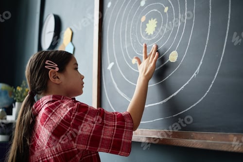 Preview: Preteen Girl Touching Solar System Diagram on Blackboard during Science Lesson