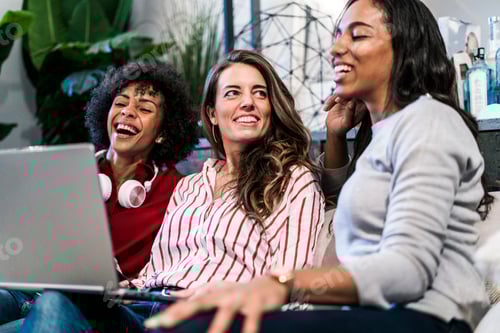 Preview: Three happy women with laptop sitting on couch